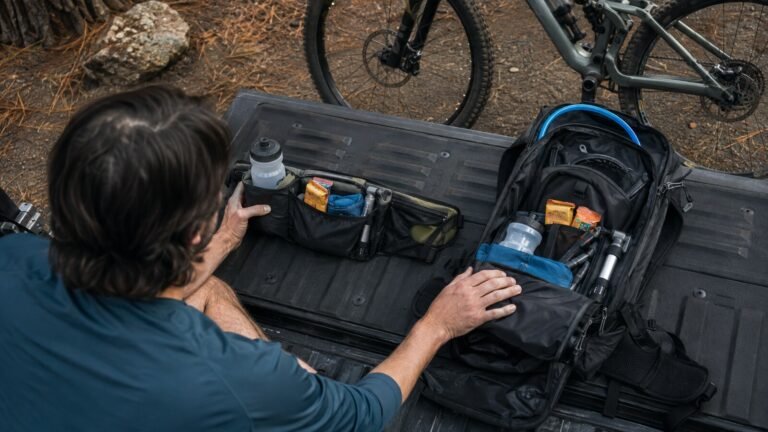 Riñonera de hidratación y mochila de MTB preparadas junto a una bicicleta